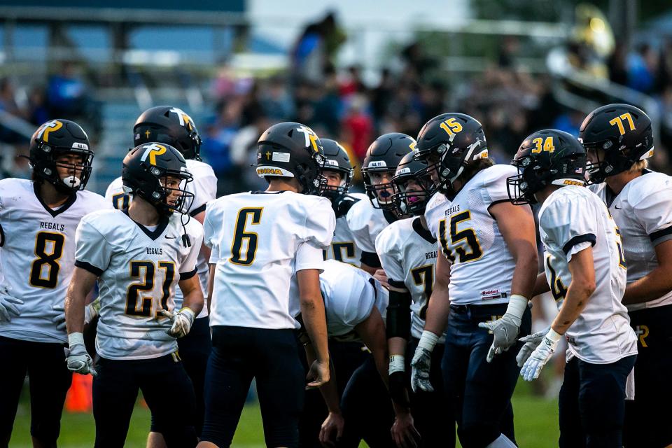 Iowa City Regina quarterback Gentry Dumont (6) huddles up with teammates during a varsity high school football game against West Liberty, Friday, Sept. 3, 2021, in West Liberty, Iowa.