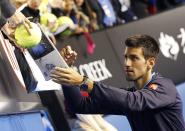 Novak Djokovic of Serbia signs autographs after defeating Stan Wawrinka of Switzerland to win their men's singles semi-final match at the Australian Open 2015 tennis tournament in Melbourne January 30, 2015. REUTERS/Athit Perawongmetha (AUSTRALIA - Tags: SPORT TENNIS)