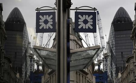 A logo of the Royal Bank of Scotland (RBS) is reflected in the window of a branch office in London November 1, 2013. REUTERS/Luke MacGregor