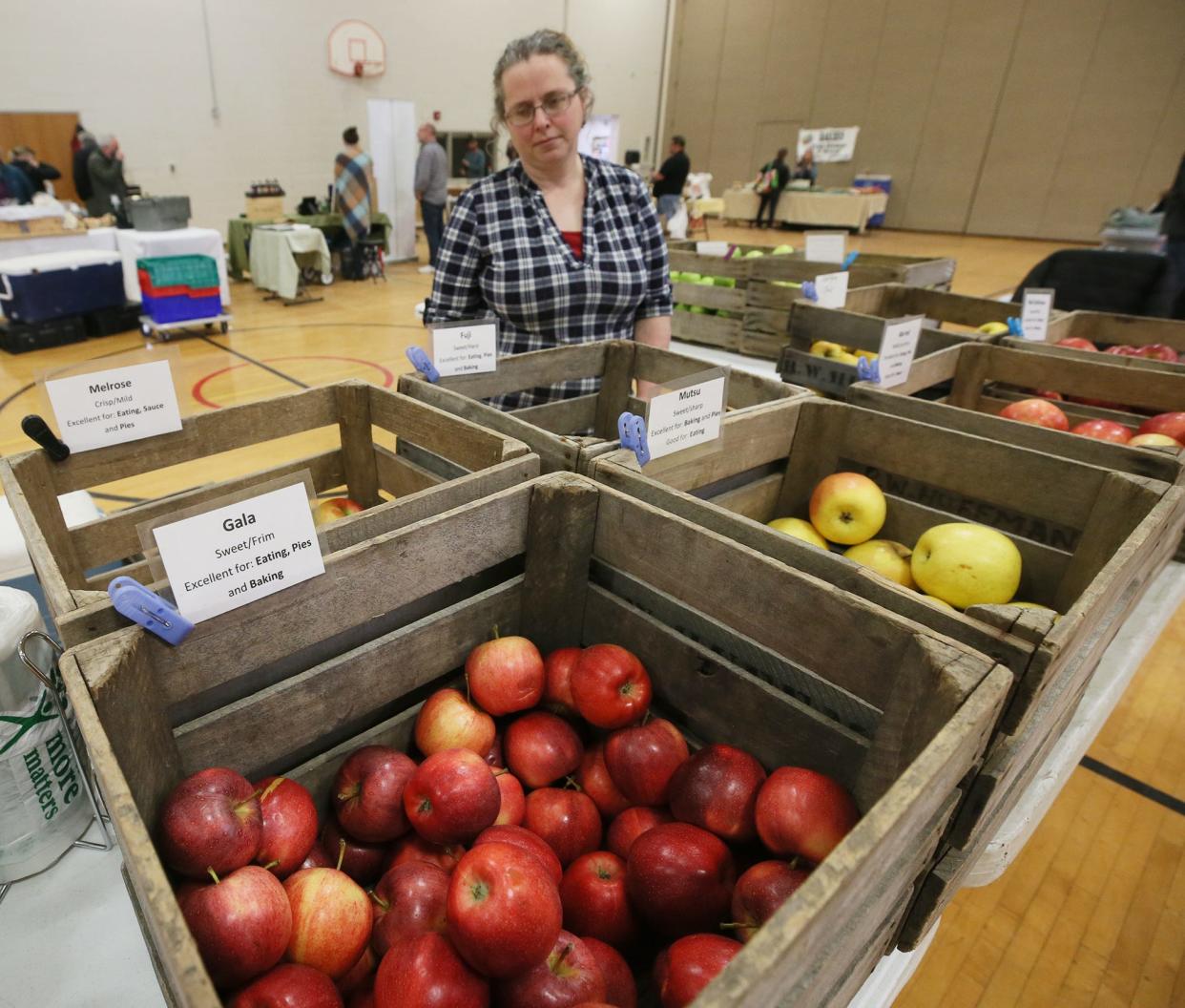 Becky Yoder of Huffman Fruit Farm looks over the apples as she waits for shoppers  Saturday at the Countryside Winter Farmers' Market at Old Trail School in Bath.
