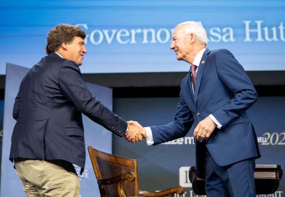 Republican presidential candidate former Arkansas Gov. Asa Hutchinson talks with moderator Tucker Carlson, left, during the Family Leadership Summit in Des Moines, Friday, July 14, 2023. 