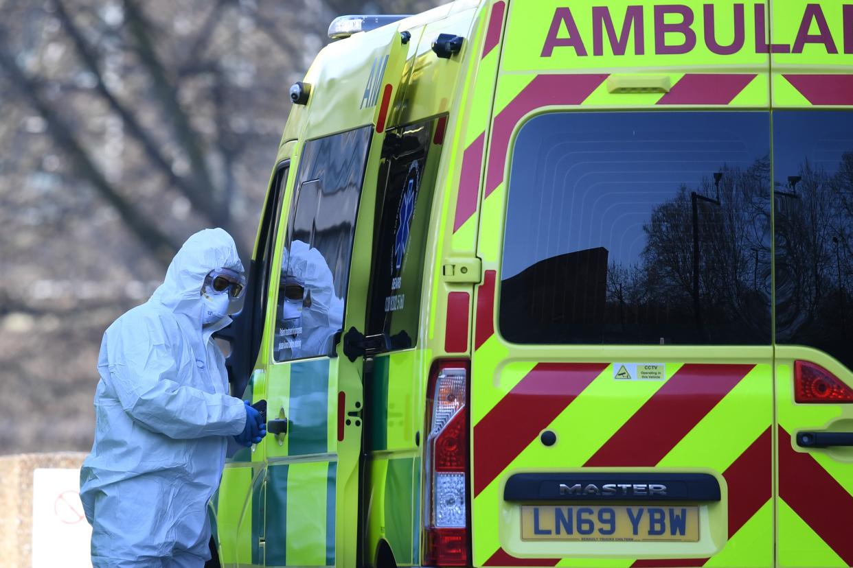 A member of the ambulance service wearing personal protective equipment is seen leading a patient (unseen) into an ambulance at St Thomas' Hospital in London on March 24, 2020. - Britain's leaders on Tuesday urged people to respect an unprecedented countrywide lockdown, saying that following advice to stay at home would stop people dying of coronavirus. (Photo by DANIEL LEAL-OLIVAS / AFP) (Photo by DANIEL LEAL-OLIVAS/AFP via Getty Images)