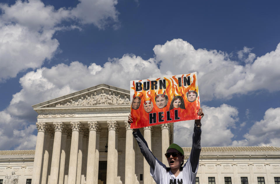 An abortion-rights protester displays a placard during a demonstration outside the Supreme Court in Washington, Saturday, June 25, 2022. The Supreme Court has ended constitutional protections for abortion that had been in place nearly 50 years, a decision by its conservative majority to overturn the court's landmark abortion cases. (AP Photo/Gemunu Amarasinghe)