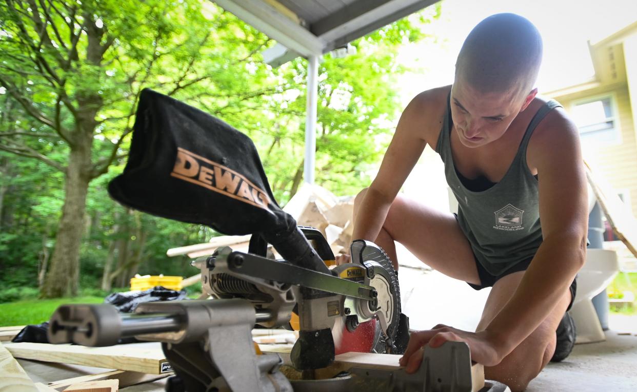 "We're still designing. We aren't designing dresses for the celebrities we used to, we're designing for ourselves — that's why you start designing, because you want something you can't find and bring it to fruition," Shawn Buitendorp, of Grand Ledge, said while using a chop saw on a bathroom remodel in Grand Ledge Wednesday, June 5, 2024. She and twin sister Claire are learning the remodeling trade working with Lakeland Remodeling. "We can still do that now, and also for others in home renovation."