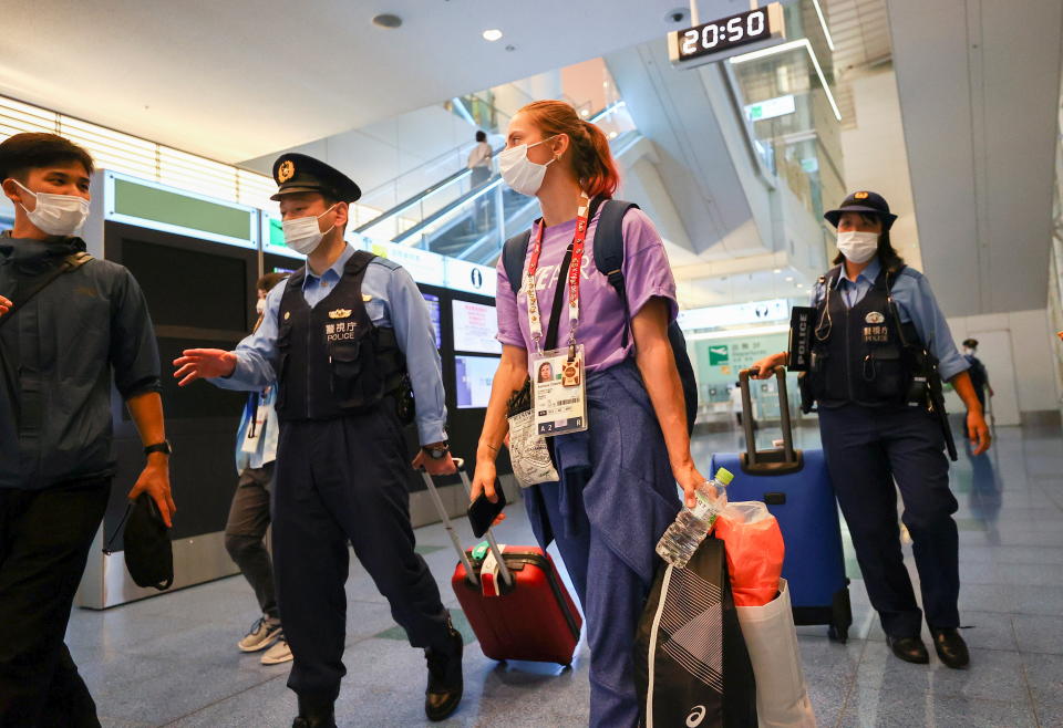 Belarusian athlete Krystsina Tsimanouskaya is escorted by police officers at Haneda international airport in Tokyo, Japan August 1, 2021.  REUTERS/Issei Kato