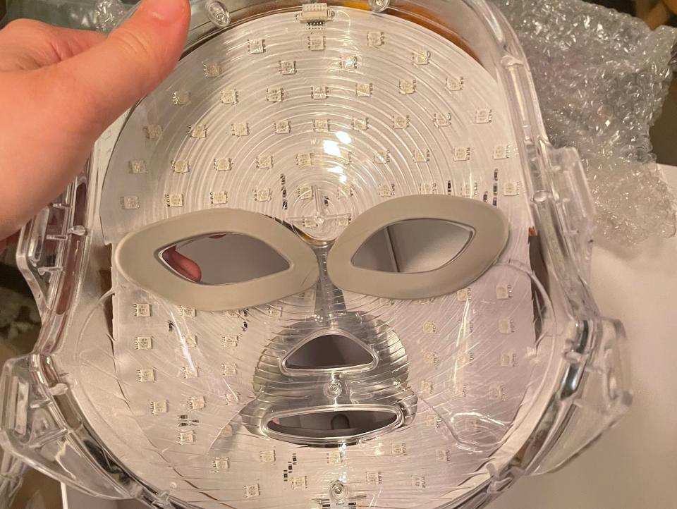 The back of an LED face mask, which has tiny square circuit-like structures and pads for your eyes.