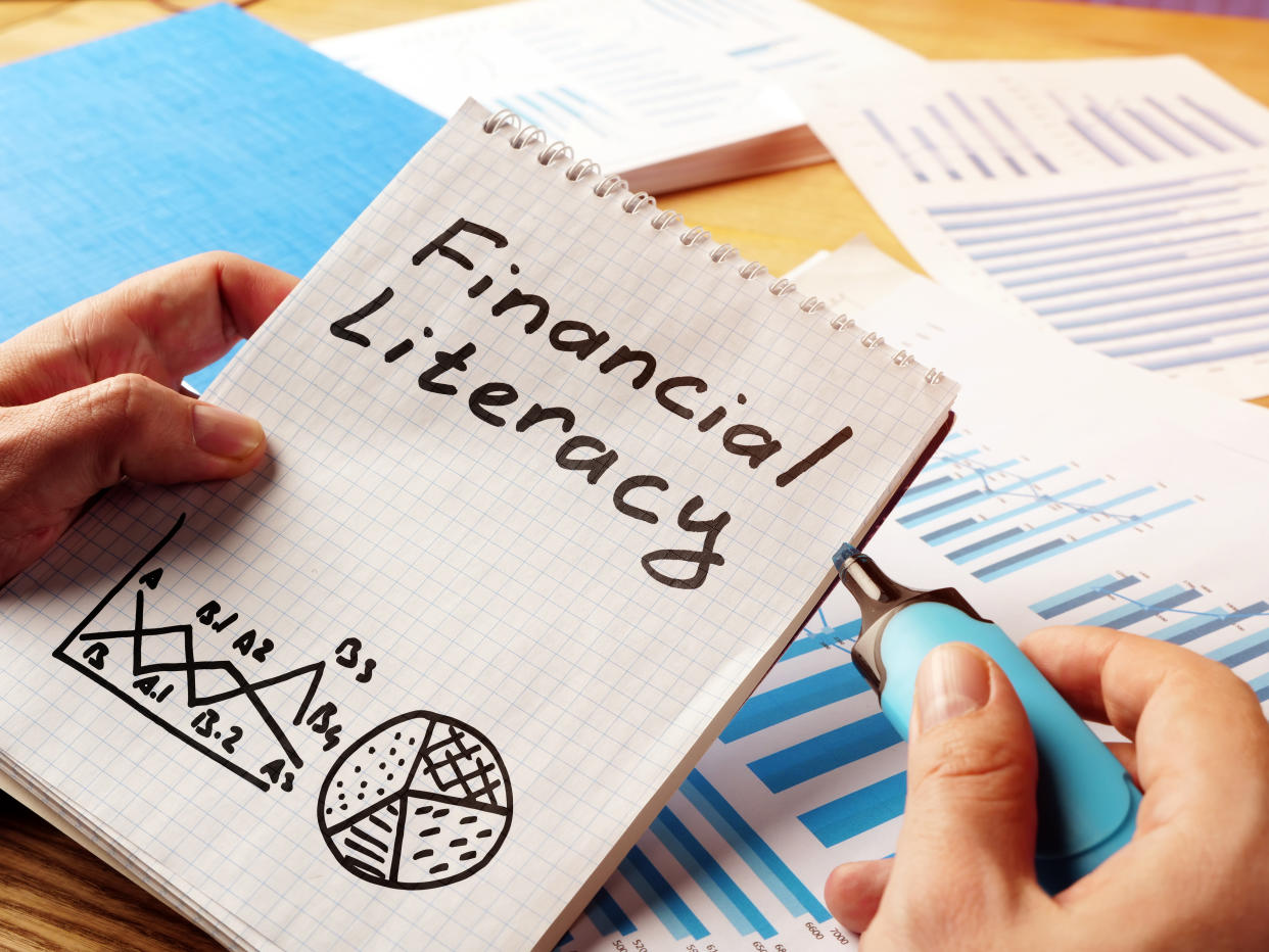 Financial literacy handwritten in the notepad.