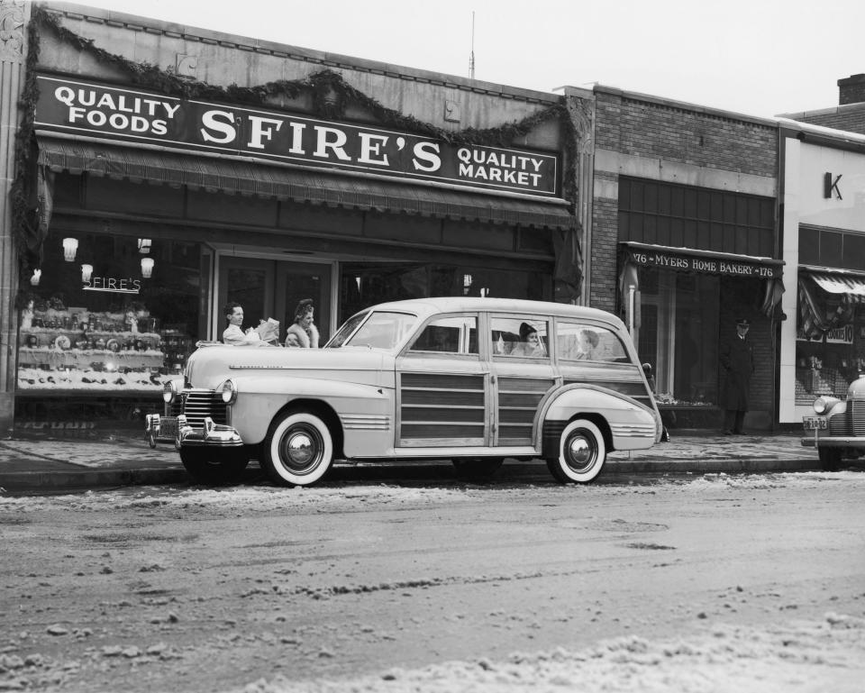 An old automobile in front of a store front.