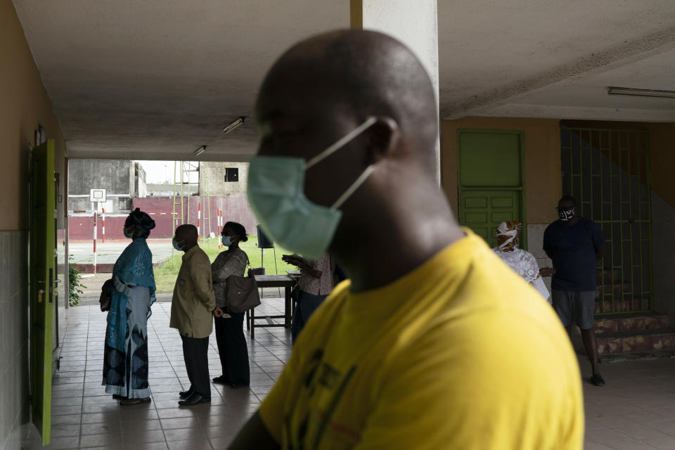 People wait in line to vote in presidential election in Abidjan, Ivory Coast, Saturday, Oct. 31, 2020. Tens of thousands of security forces deployed across Ivory Coast on Saturday as the leading opposition parties boycotted the election, calling President Alassane Ouattara's bid for a third term illegal. (AP Photo/Leo Correa)