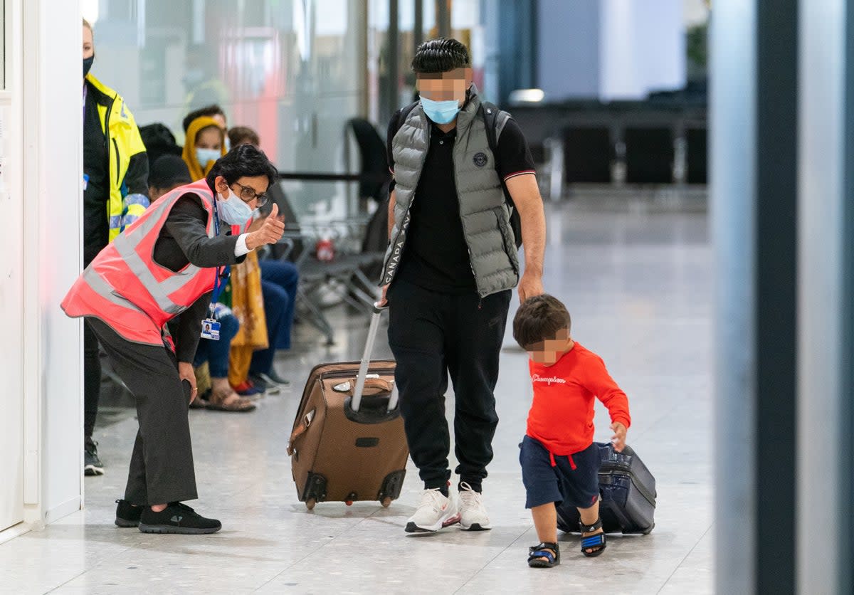 A member of security staff gives a thumbs up to refugees arriving from Afghanistan at Heathrow airport in August 2021  (Getty)