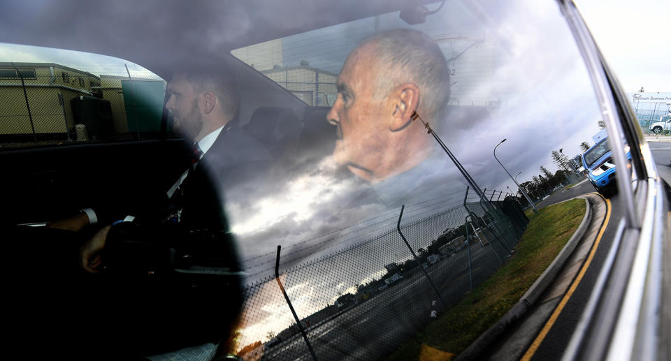 Chris Dawson is seen in a police car on arrival at Gold Coast airport on Thursday morning. Image: AAP