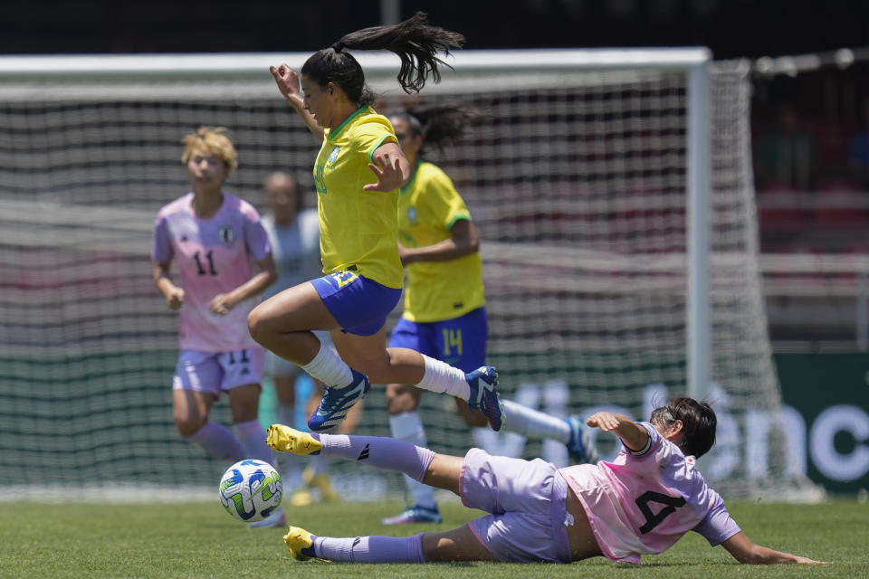 Brazil's Duda Sampaio escapes with the ball from Japan's Saki Kumagi, on the ground, during a women's friendly soccer match at Morumbi stadium in Sao Paulo, Brazil, Sunday, Dec. 3, 2023. (AP Photo/Andre Penner)