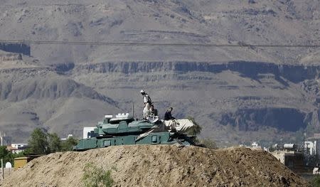 Houthi fighters sit on a tank near the Presidential Palace in Sanaa March 25, 2015. REUTERS/Khaled Abdullah