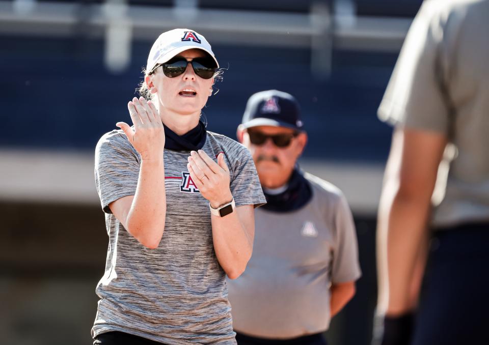 Arizona associate head coach Caitlin Lowe (with head coach Mike Candrea) instructs the Wildcats during practice.