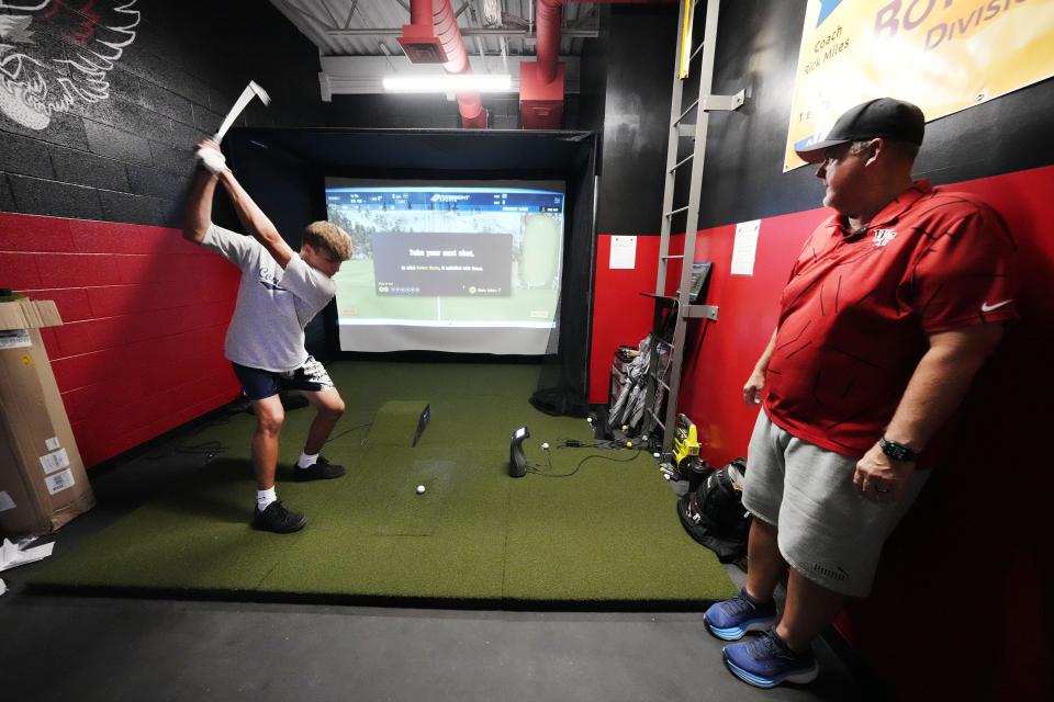 Williams Field golf coach Rick Miles works with senior Ben Carr in the golf simulator room at Williams Field High School in Gilbert on Sept. 11, 2023.