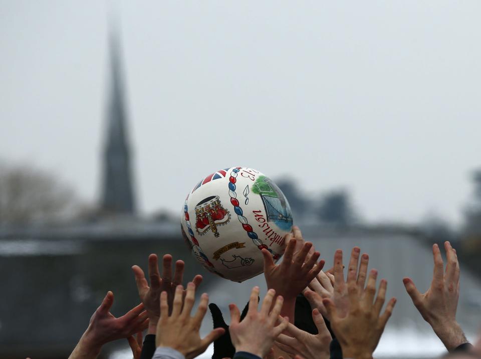 The ball is momentarily suspended in the air as a crowd of hands reach up to grab it (Reuters)