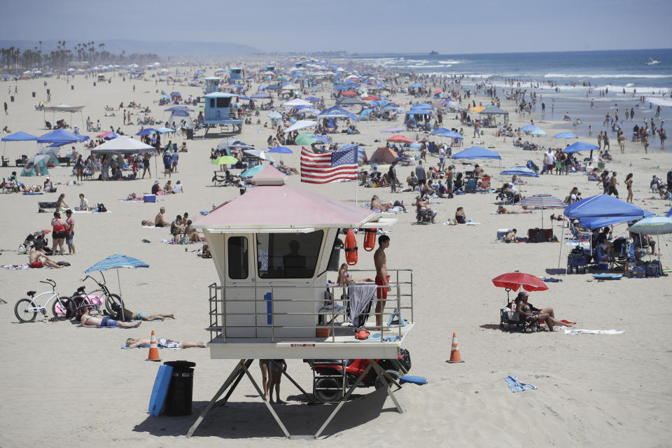 A lifeguard keeps watch over a packed beach Saturday, June 27, 2020, in Huntington Beach, Calif. (AP Photo/Marcio Jose Sanchez)