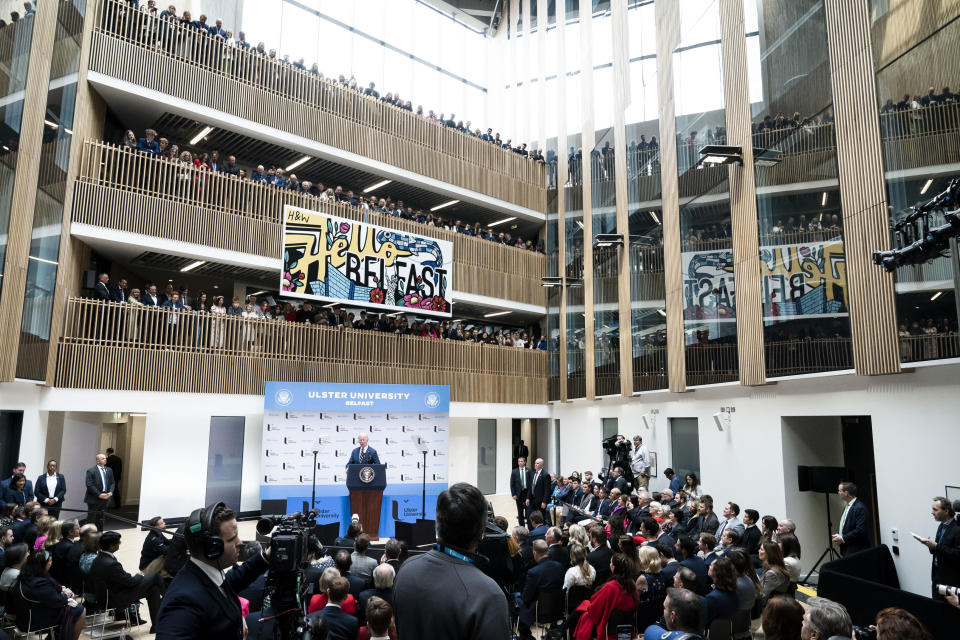 Crowds of people watch from balconies as US President Joe Biden delivers his keynote speech at Ulster University in Belfast, Northern Ireland, Wednesday, April 12, 2023. (Aaron Chown/PA via AP)