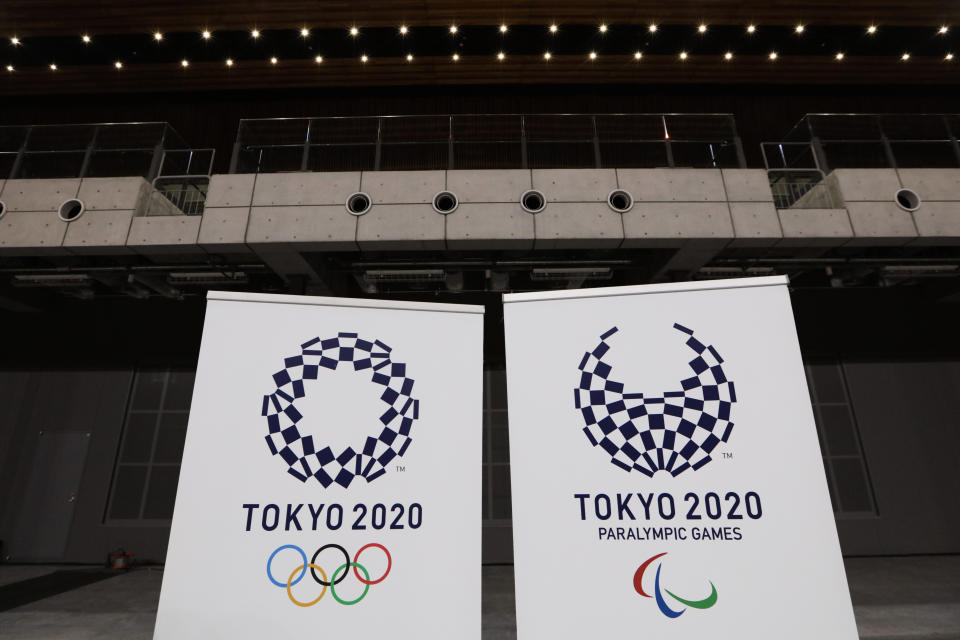 FILE - In this Feb. 2, 2020, file photo, two logo for the Tokyo 2020 Olympics and Paralympics, are displayed at a grand opening ceremony of the Ariake Arena, a venue for volleyball at the Tokyo 2020 Olympics and wheelchair basketball during the Paralympic Games, in Tokyo. A test event for the Tokyo Olympics scheduled for later February, that would have involved some non-Japanese athletes is being rejiggered because of fear of the spreading virus from China. It will now involve only Japanese athletes.(AP Photo/Jae C. Hong)