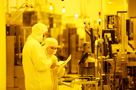 FILE PHOTO: Technicians work at Israeli chipmaker TowerJazz's plant in Migdal HaEmek, northern Israel September 13, 2017. Picture taken September 13, 2017. REUTERS/Ronen Zvulun/File Photo