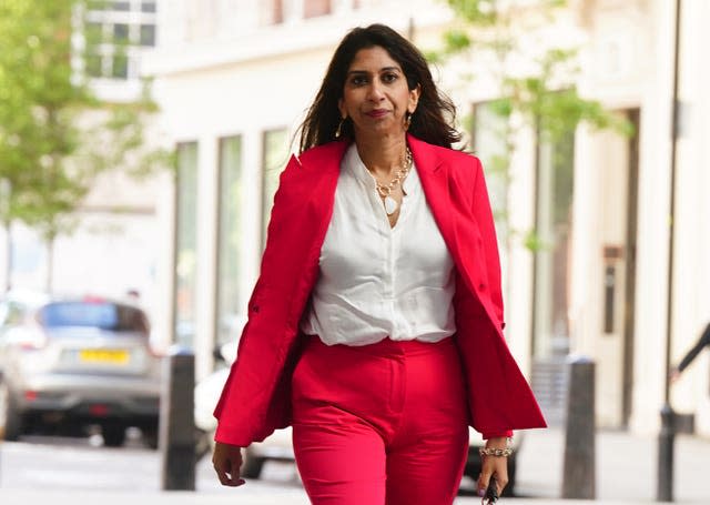 Suella Braverman walking along a street