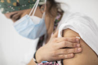 Spanish nurse Irene Vazquez, 28, pauses after receiving the second dose of the Pfizer-BioNTech COVID-19 vaccine at the Nurse Isabel Zendal Hospital in Madrid, Spain, Monday, Feb. 1, 2021. (AP Photo/Bernat Armangue)