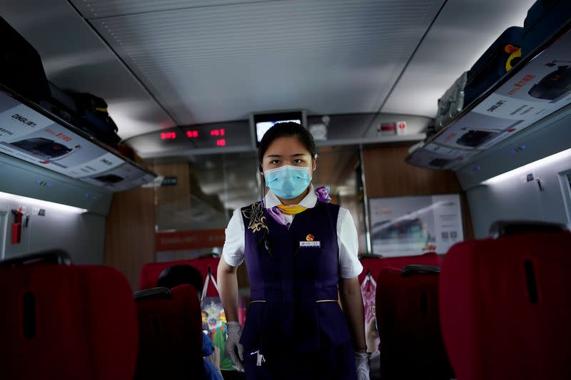 FILE PHOTO: A train staff member walks on a high-speed train at Wuhan Railway Station, in Wuhan