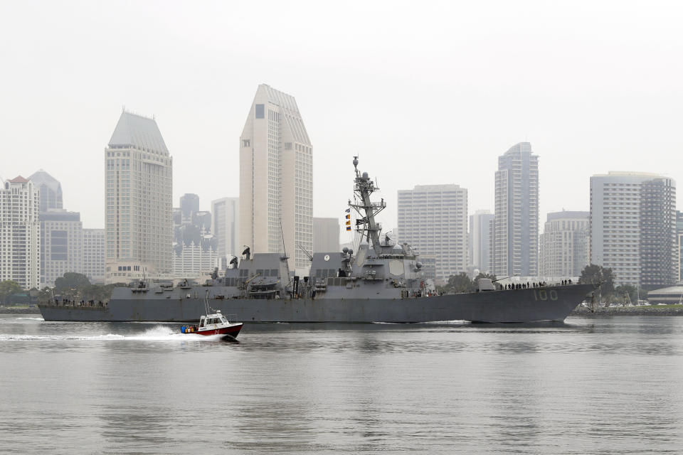 The USS Kidd passes downtown San Diego as it returns to Naval Base San Diego, Tuesday, April 28, 2020, seen from Coronado, Calif. As the American destroyer heads home with an outbreak in cases of COVID-19, relatives and friends of the 350 crew members prayed for their health while Navy officials vowed to keep the outbreak, the second to strike a Navy vessel at sea, from spreading. (AP Photo/Gregory Bull)