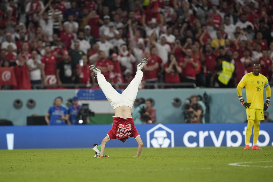 A Tunisian soccer fan invades the pitch during the World Cup group D soccer match between Tunisia and France at the Education City Stadium in Al Rayyan , Qatar, Wednesday, Nov. 30, 2022. (AP Photo/Christophe Ena)