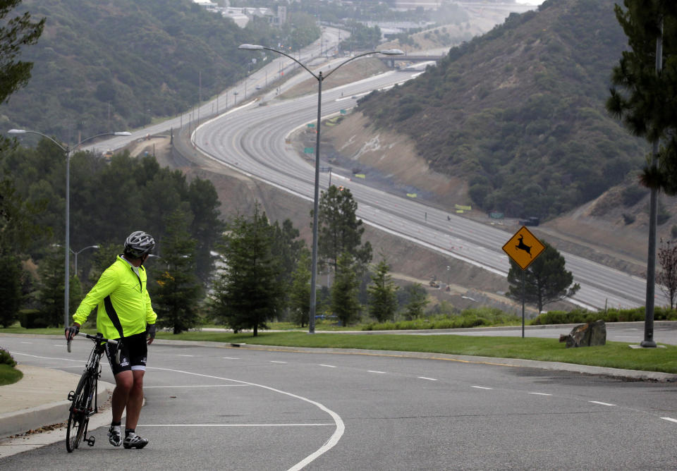 Jerry Wenker watches Interstate 405 during the freeway closure in Los Angeles, Saturday, July 16, 2011. The 10-mile stretch of one of the nation's busiest freeways has turned into a virtual ghost road. (AP Photo/Jae C. Hong)