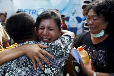 A woman (C) cries after confirming that her brother was among the victims of an Indonesian military C-130 Hercules transport plane that crashed into a residential area, outside the Adam Malik hospital in Medan, Indonesia North Sumatra province July 2, 2015. REUTERS/Beawiharta