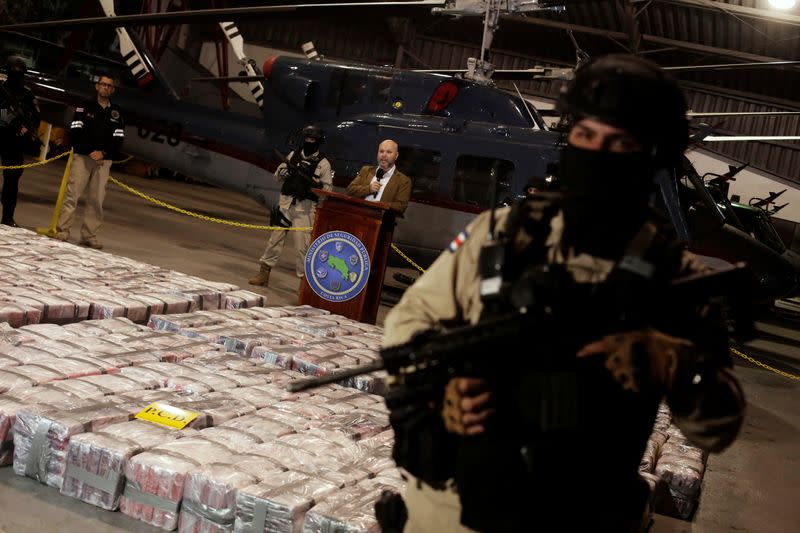 Police officer is seen in front of packages containing cocaine seized during an operation in the Caribbean, as Michael Soto, Minister of Public Security, speaks to the media in Alajuela