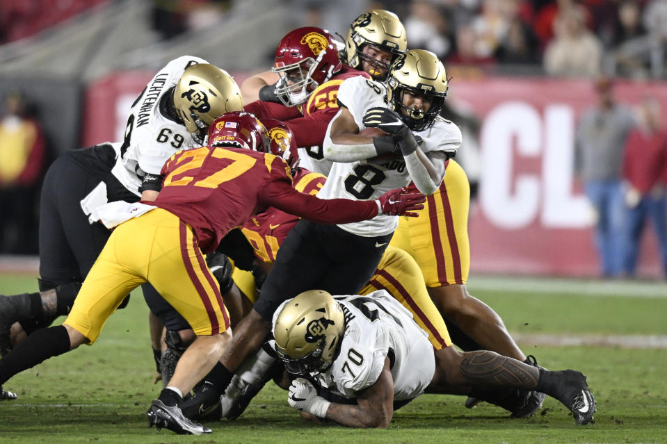 Colorado running back Alex Fontenot rushes for a first down against Southern California defensive back Bryson Shaw (27) and other during the first half of an NCAA college football game Friday, Nov. 11, 2022, in Los Angeles. (AP Photo/John McCoy)