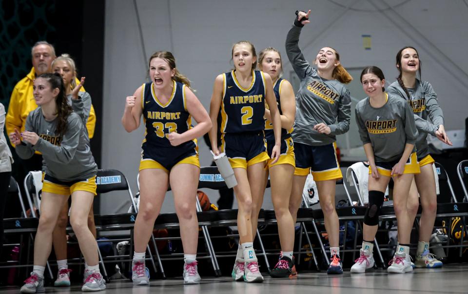 The Airport bench cheers during Airport's 64-46 victory over Grosse Ile in the finals of the Division 2 District at Summit Academy on Friday, March 8, 2024.