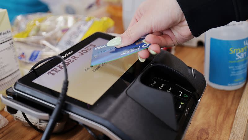 A woman uses her card to make her purchase at Trader Joe’s in Draper on March 3, 2023.