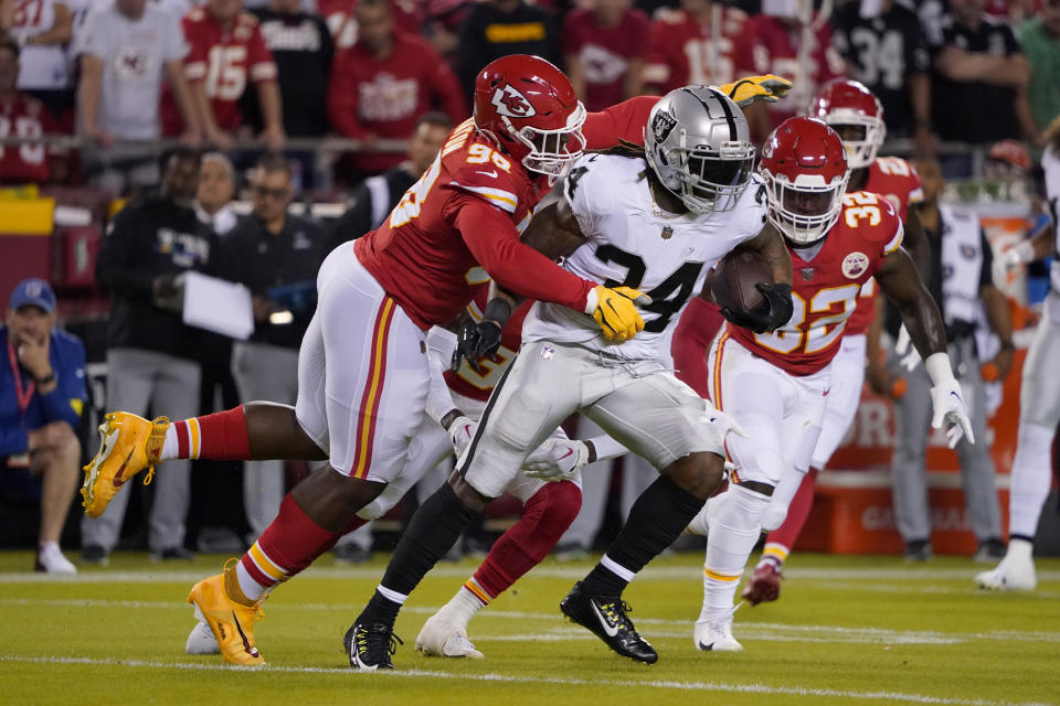 Las Vegas Raiders running back Brandon Bolden (34) runs with the ball as Kansas City Chiefs defensive tackle Tershawn Wharton, left, and linebacker Nick Bolton (32) defend during the first half of an NFL football game Monday, Oct. 10, 2022, in Kansas City, Mo. (AP Photo/Ed Zurga)