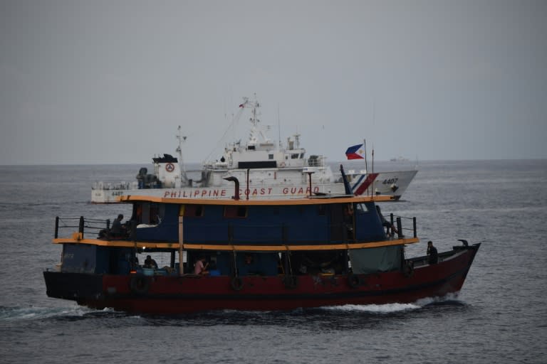 Un buque de la guardia costera de Filipinas escolta a unos barcos que suministran material a un buque de la marina en las disputadas aguas del mar de China Meridional el 22 de agosto de 2024 (Ted Aljibe)