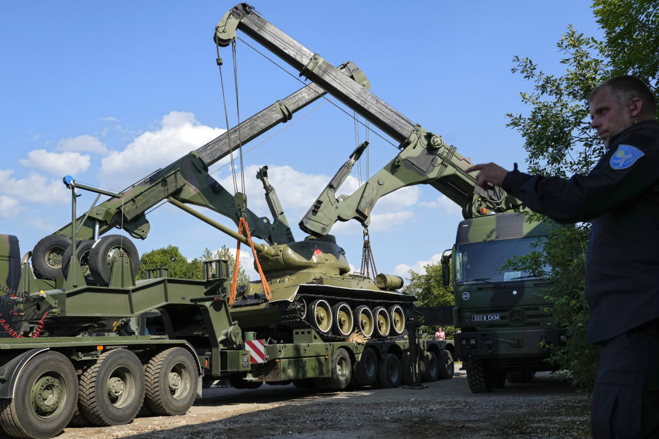 Cranes unload a Soviet T-34 tank which was installed as a monument in Narva from a trailer at a military museum in Tallinn, Estonia, Tuesday, Aug. 16, 2022. Estonia's government said Tuesday it has decided to remove a Soviet monument in a border town of Narva sitting in the Baltic country's Russian-speaking part, with the prime minister saying the reason for the dismantling is that it represents a risk for public order. (AP Photo/Sergei Grits)