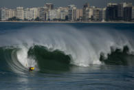 A body surfer rides a giant wave during high tide in Copacabana beach in Rio de Janeiro, Brazil.