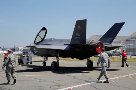 U.S. airmen walk next to a Lockheed Martin F-35 Lightning II aircraft as it is moved. REUTERS/Pascal Rossignol