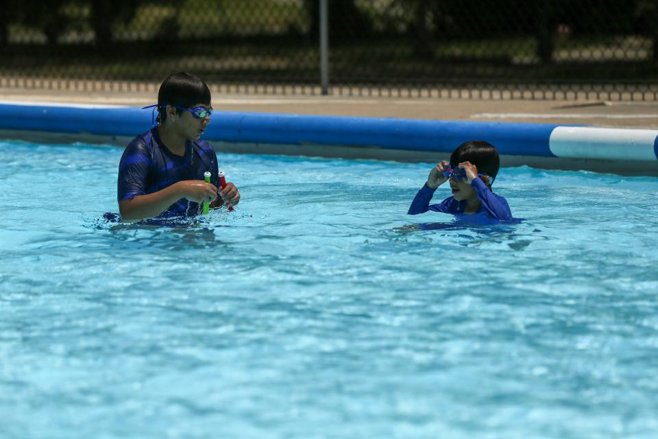 From left, brothers Christian, 12, and William Menchaca, 8, get ready to dive underwater to retrieve a toy baton at Oso Pool Friday, July 7, 2023.