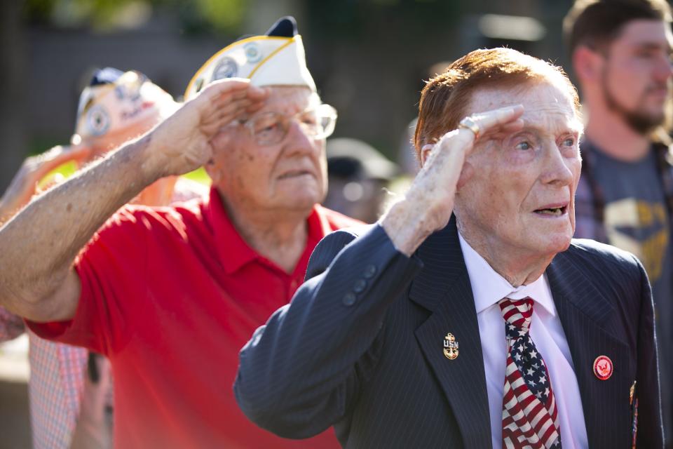 Pearl Harbor survivors Jack Holder (front right), a veteran of the U.S. Navy, and Edward Miklavcic (background left), a veteran of the then U.S. Army Air Forces, salute during a Pearl Harbor Remembrance Day event in Phoenix on the 77th anniversary of the attack on Pearl Harbor, on December 7, 2018.