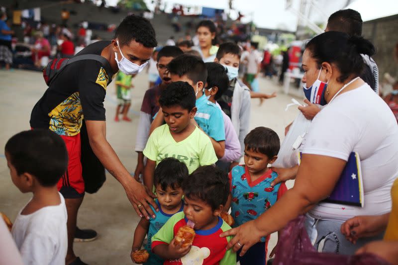 Venezuelan migrant children line up inside a coliseum where a temporary camp has been set up, after fleeing their country due to military operations, according to the Colombian migration agency, in Arauquita