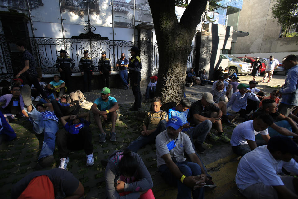 Scores of Central American migrants, representing the thousands participating in a caravan trying to reach the U.S. border, rest in front of the office of the United Nation's human rights body, after undertaking an hours-long march to demand buses, in Mexico City, Thursday, Nov. 8, 2018. Members of the caravan which has stopped in Mexico City demanded buses to take them to the U.S. border, saying it is too cold and dangerous to continue walking and hitchhiking.(AP Photo/Rebecca Blackwell)