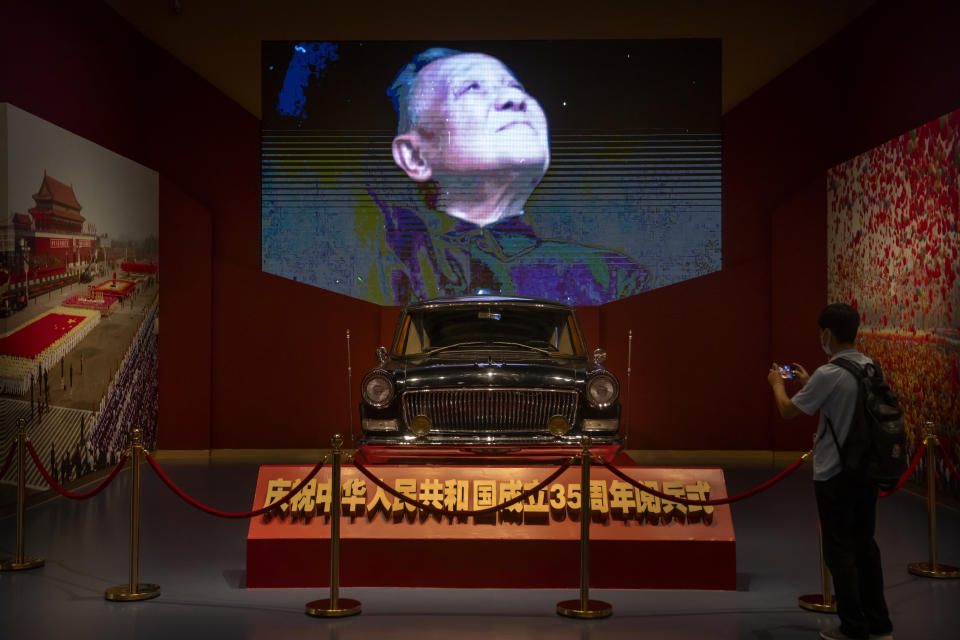 A visitor takes a photo as a video display shows an image of Chinese leader Deng Xiaoping at the newly-completed Museum of the Communist Party of China in Beijing, Friday, June 25, 2021. The communists have ruled China single-handedly for more than 70 years since Mao led them to power in 1949. After his death in 1976, they started a sharp turn under then-leader Deng Xiaoping, embracing a market economy that has transformed what was a poor country into an economic power. (AP Photo/Mark Schiefelbein)