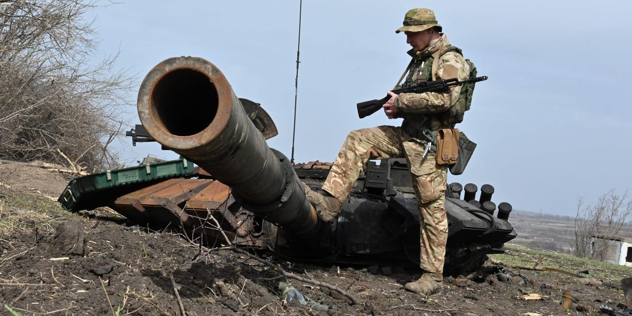 A Ukrainian soldier checks the wreckage of a burnt Russian tank outside of the village of Mala Rogan, east of Kharkiv, on April 1, 2022, amid Russian invasion of Ukraine.