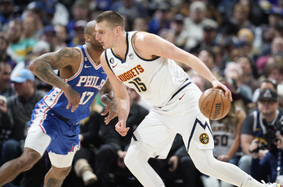 Denver Nuggets center Nikola Jokic, front, drives past Philadelphia 76ers forward P.J. Tucker in the first half of an NBA basketball game, Monday, March 27, 2023, in Denver. (AP Photo/David Zalubowski)