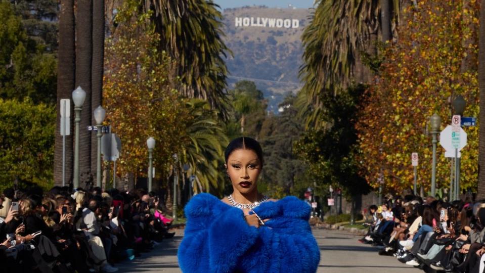 cardi b walks balenciaga's fall 2024 outdoor runway in an electric blue coat