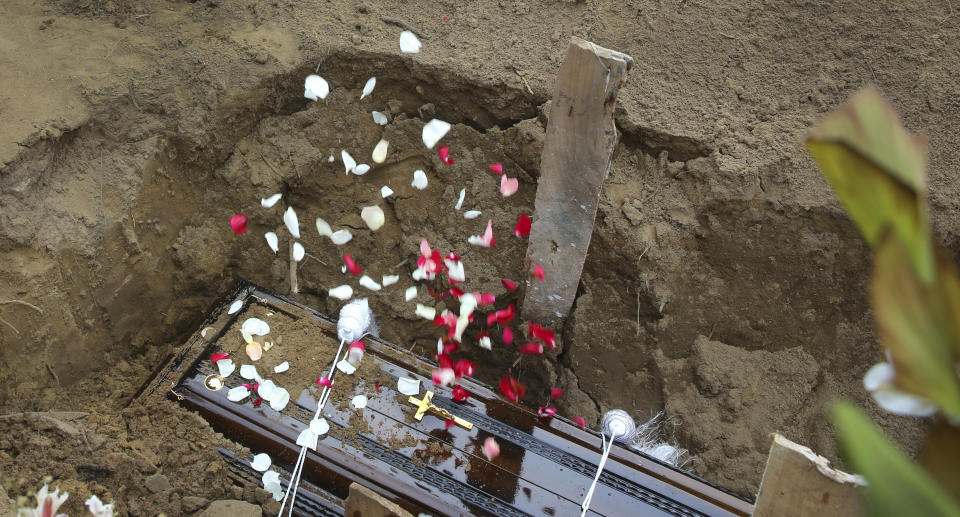 Relatives throw flower petals on the coffin of Dhami Brandy, 13, a victim of Easter Sunday's bomb blast at St. Sebastian Church, in Negombo, Sri Lanka Thursday, April 25, 2019. The U.S. Embassy in Sri Lanka warned Thursday that places of worship could be targeted for militant attacks over the coming weekend, as police searched for more suspects in the Islamic State-claimed Easter suicide bombings that killed over 350 people. (AP Photo/Manish Swarup)