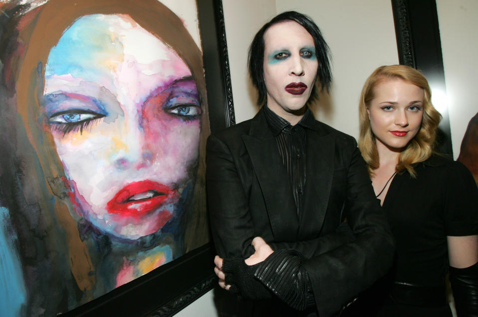 Manson and Wood stand next to one of his paintings